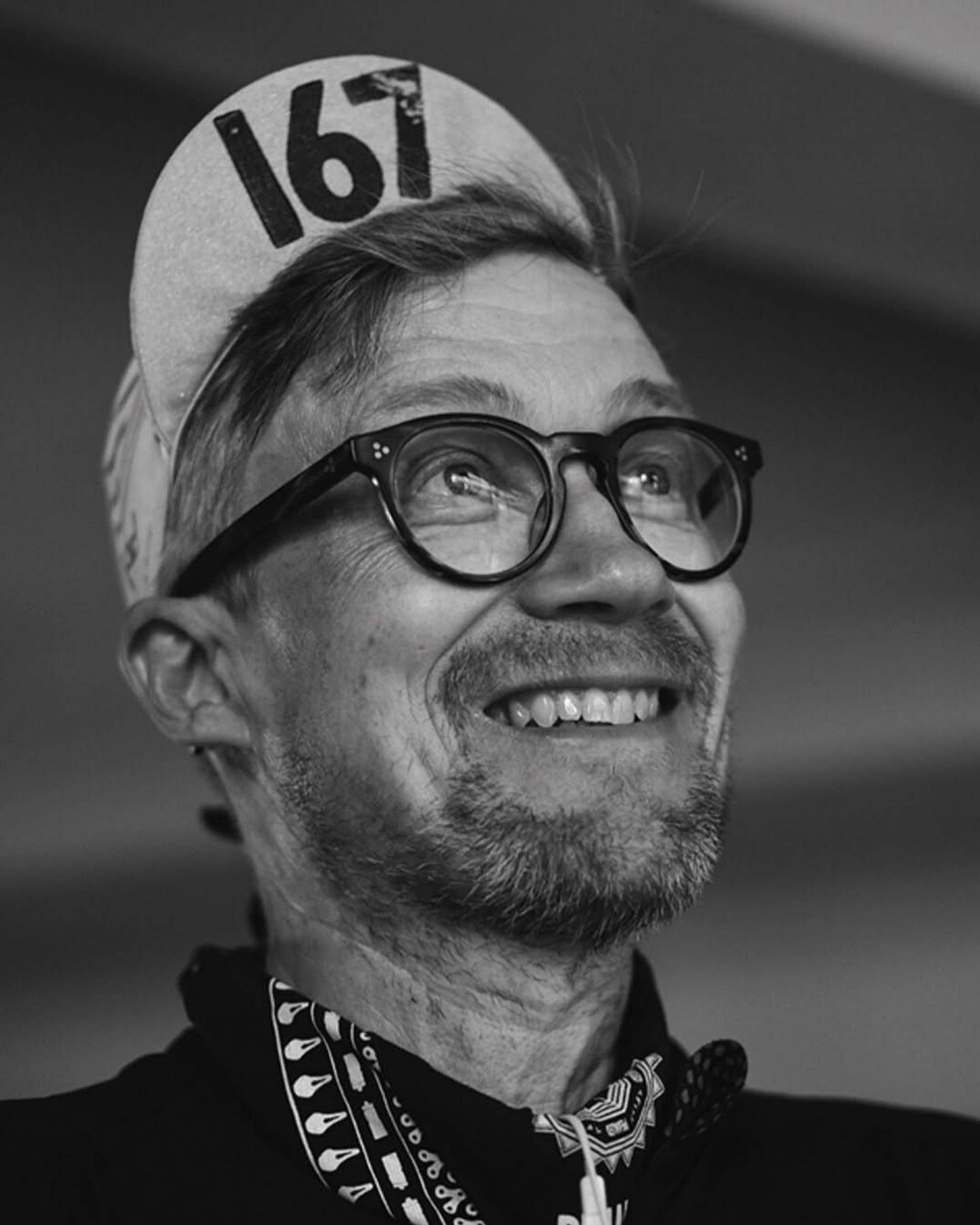 Portrait of Mika Virtonen in a cycling cap and round glasses, smiling